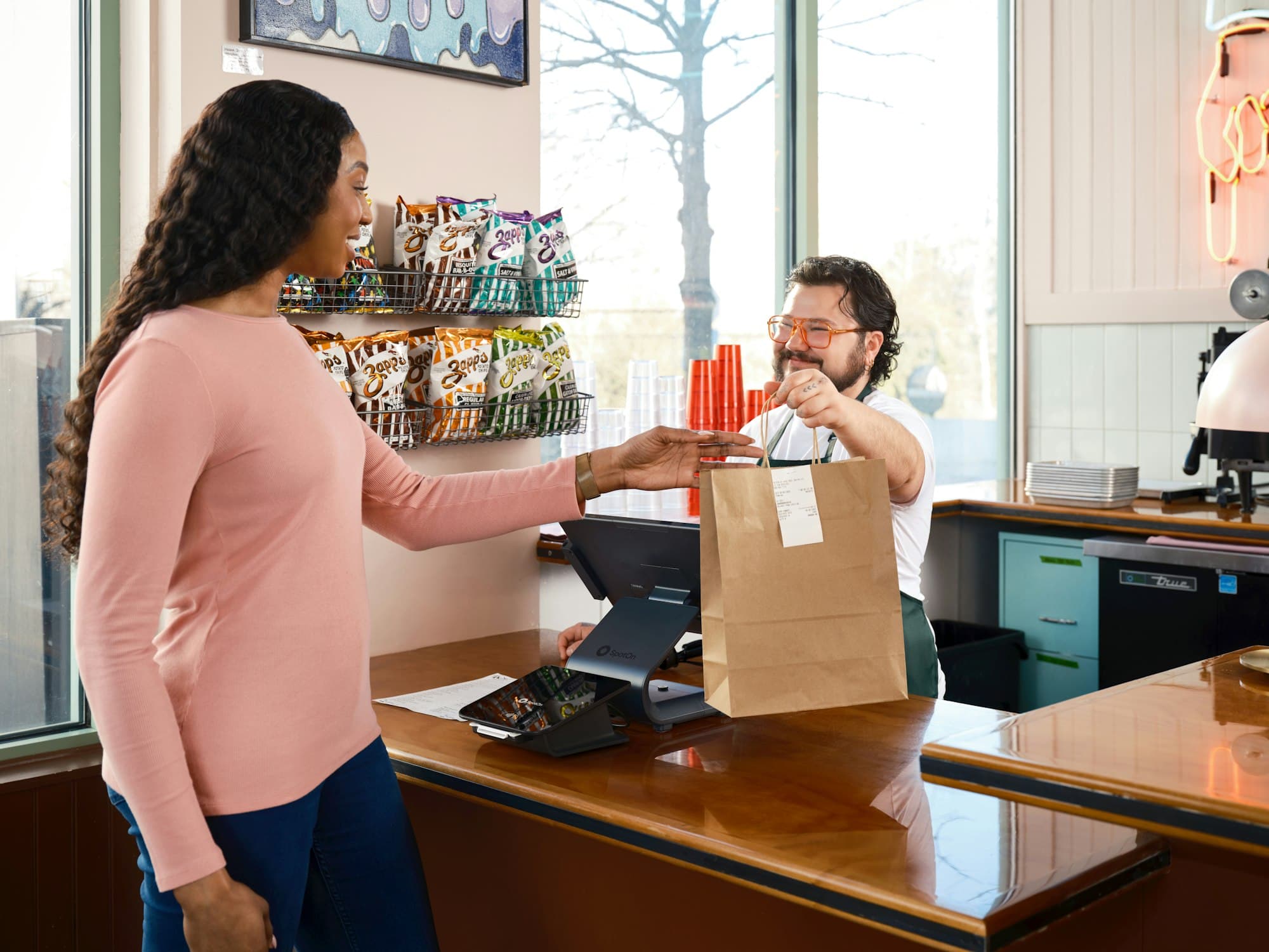 A brand ambassador helping a customer at a counter.