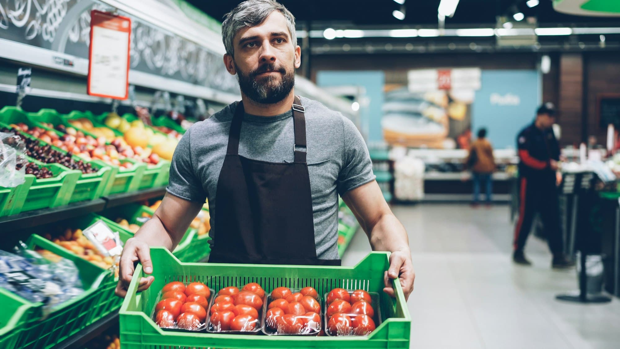 A retail worker carefully placing product on a shelf.